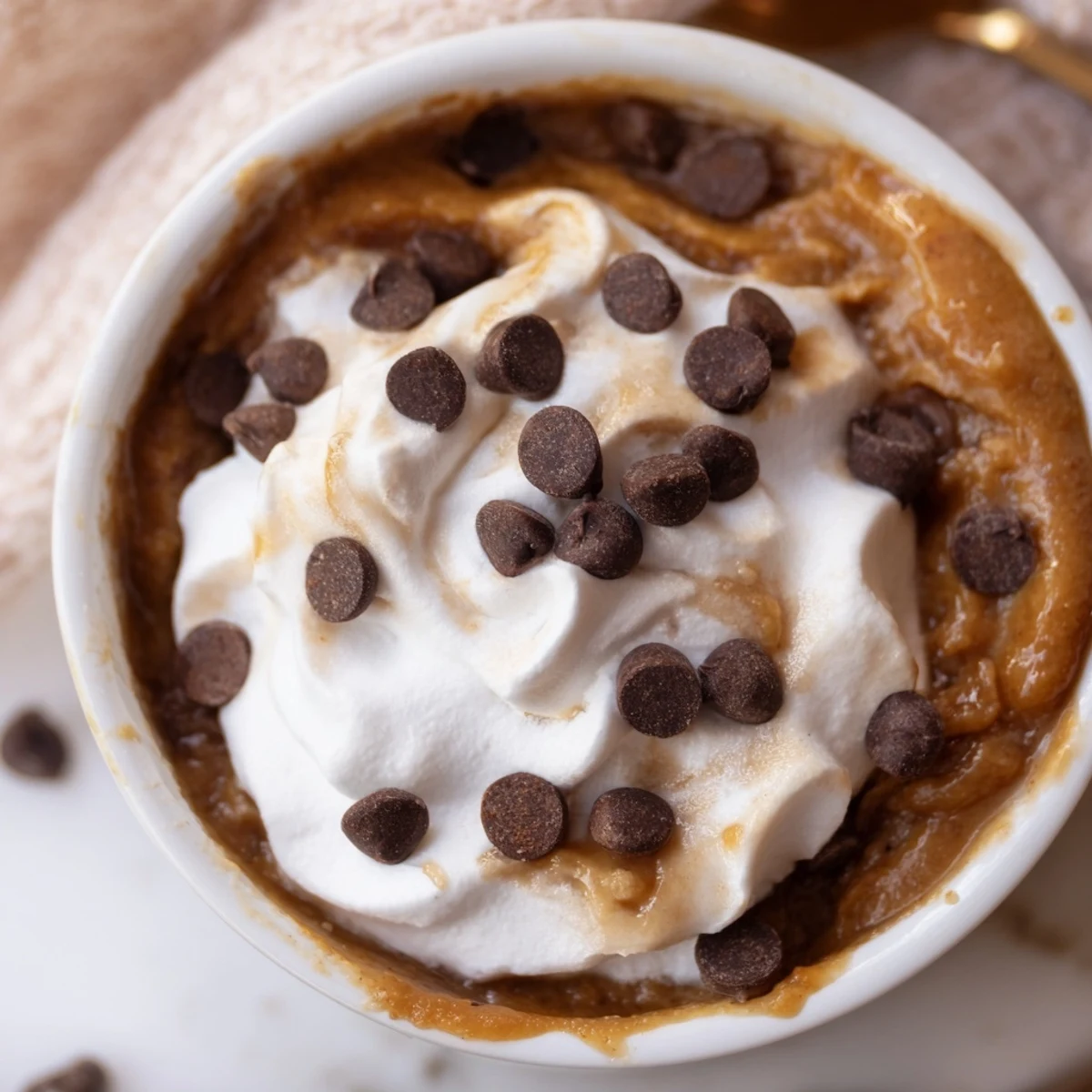 Indulge in Thanksgiving Chocolate Chip Pumpkin Pudding topped with cream and chocolate chips.  