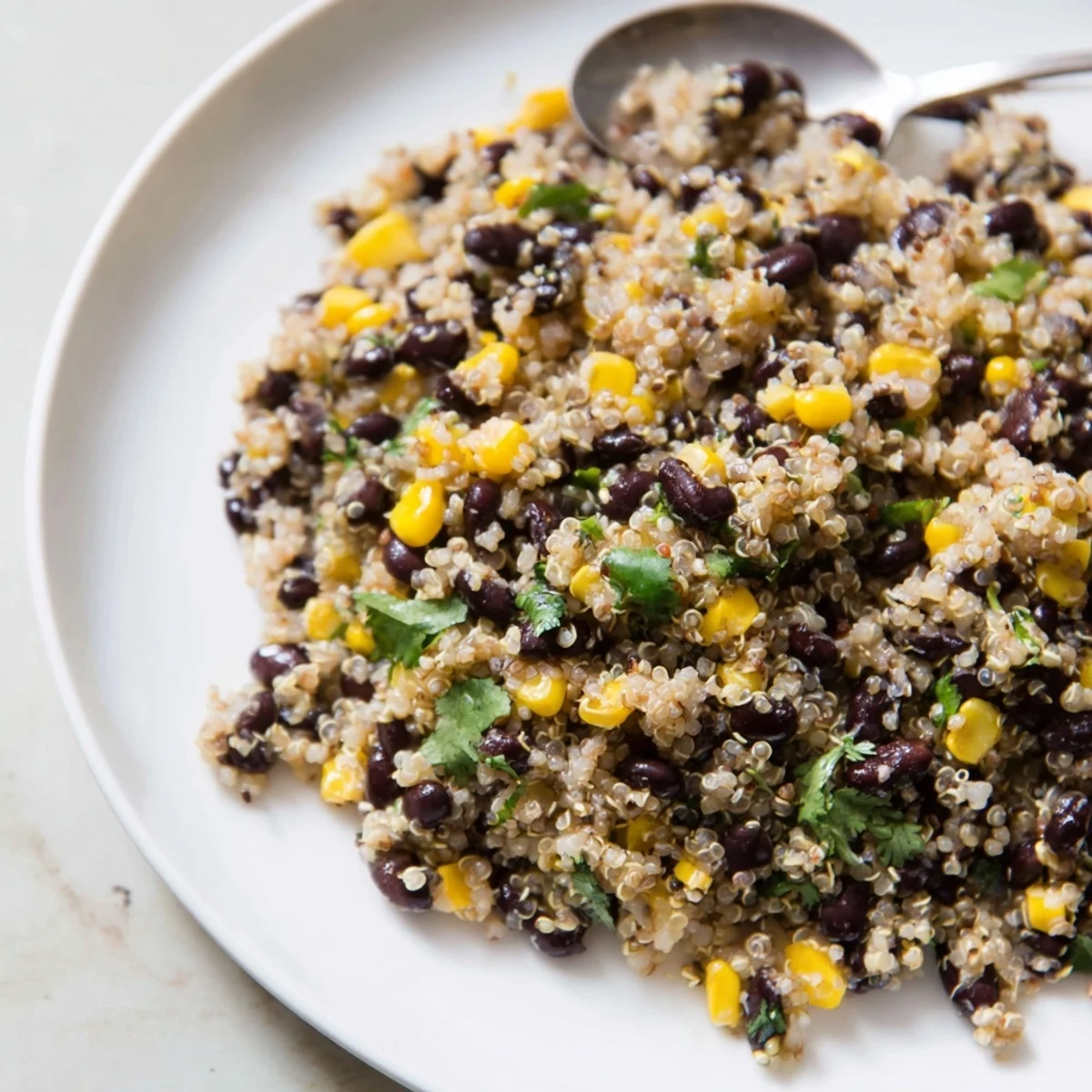 Colorful Quinoa and Black Bean Salad topped with fresh cilantro and lime dressing.