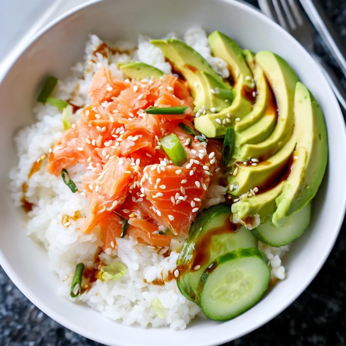 Delicious leftover salmon & rice bowl topped with fresh avocado and sesame seeds.  