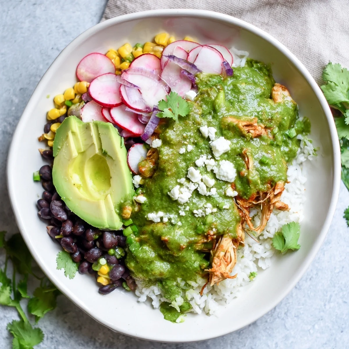 Vibrant Green Enchiladas Rice Bowl with avocado slices, ready to enjoy a Tex-Mex dinner quickly.