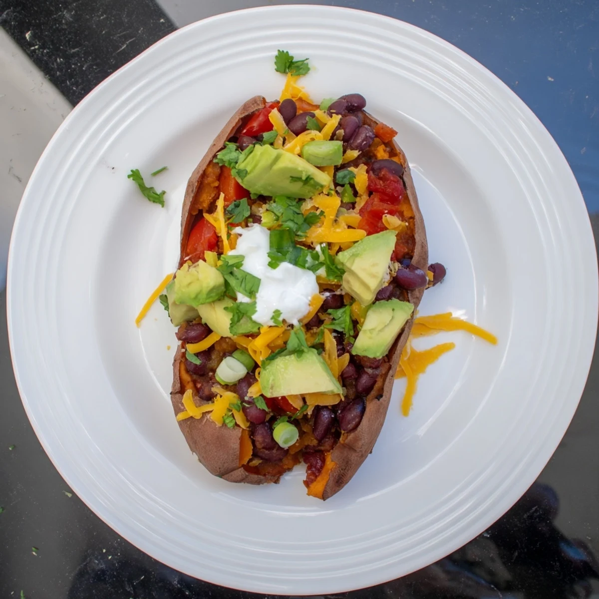 A close-up shot of steaming Savory Baked Sweet Potato Chili Boats topped with cheese and cilantro.