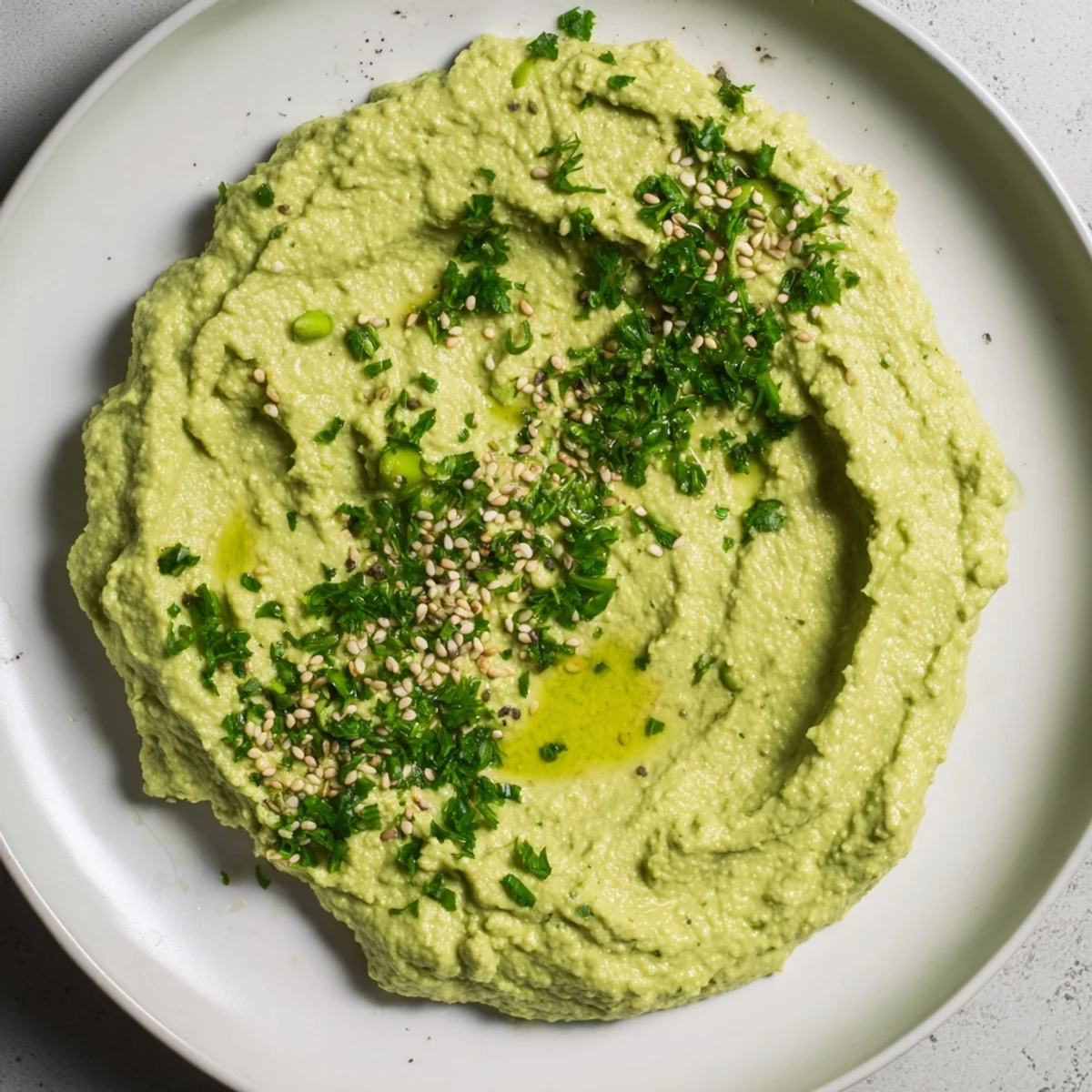 A close-up of smooth Edamame Hummus, showcasing its bright texture and perfect for spreading on pita.