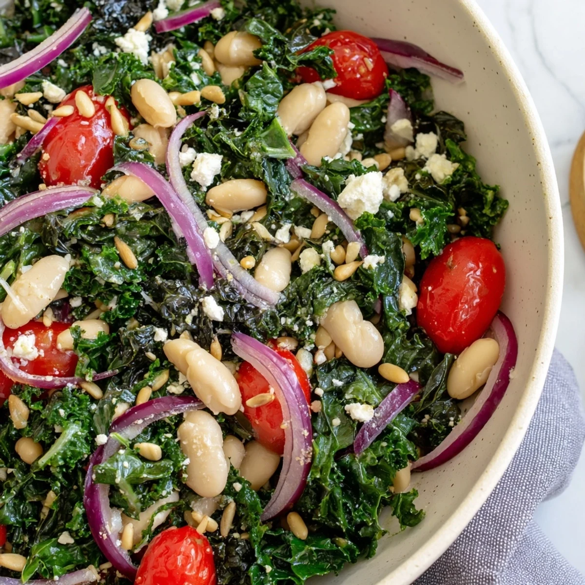 A large serving bowl of White Bean and Kale Salad, glistening with olive oil and fresh lemon, ready for a family-style dinner.