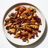 A close-up of a rustic, textured bowl filled with delicious Acorn & Oak Snack Mix.