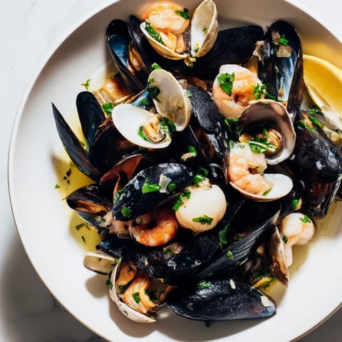 Steaming Shellfish & Seafood Medley overflowing on a plate, a vibrant mix of fresh seafood ready to eat.