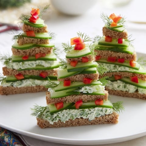 Cucumber and cream cheese tree stacks showcasing fresh cucumber arranged on creamy, herbed sandwiches, ready to enjoy.