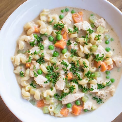 Creamy Chicken Pot Pie Pasta Soup, a comforting bowl of pasta, chicken, and vegetables, ready to eat.