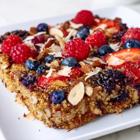 Steaming-hot Berry Quinoa Breakfast Bake with vibrant berries atop golden, baked quinoa, ready to serve.