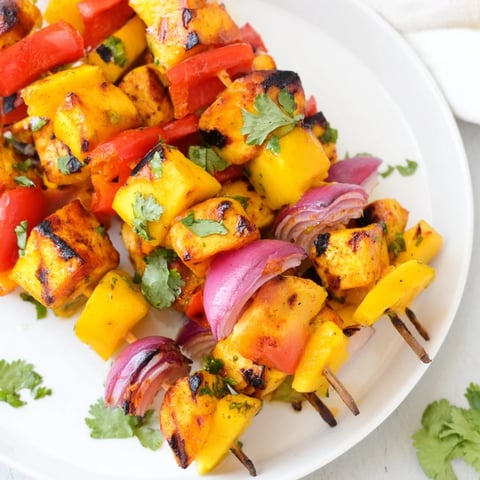 Grilled mango lime chicken skewers with vibrant peppers, a flavorful and juicy summertime meal.