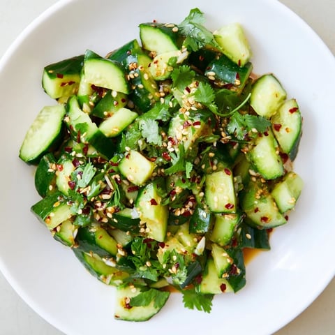 Bright, close-up of Chinese Spicy Smashed Cucumber Salad: crunchy cucumbers tossed in a rich, savory dressing.