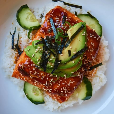 Emily Mariko-Inspired Sticky Orange Gochujang Salmon Bowl, with a glistening, glazed salmon fillet and colorful toppings.