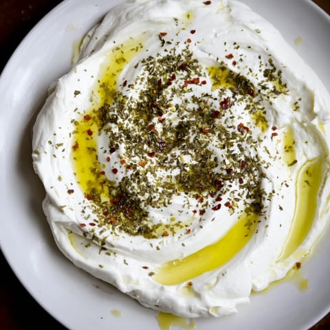 Homemade Levantine labneh cheese drizzled with olive oil, a creamy Middle Eastern appetizer waiting to be served.