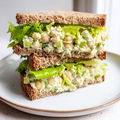 Vegan chickpea salad sandwich with fresh lettuce, perfect for quick lunches at home.  