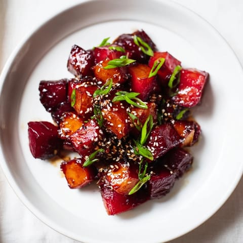 This image shows glistening Miso Roasted Winter Vegetables, beautifully caramelized and ready to serve with optional sesame seeds.