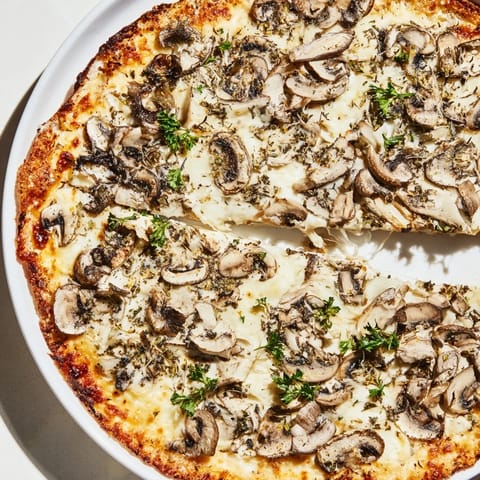 Enjoy a close-up of a melty, flavorful Frozen Pizza Upgrade with fresh herbs and a crisp crust.