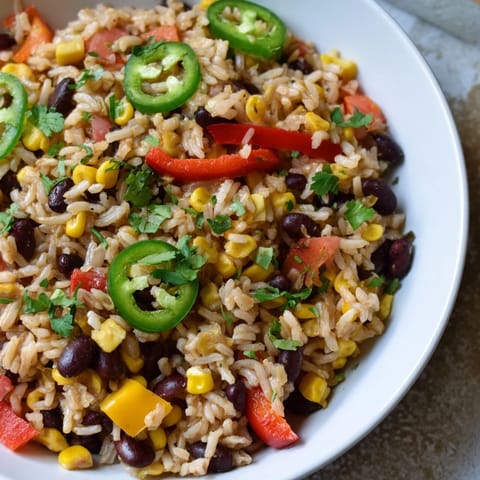 A close-up of the fully cooked One-Pot Mexican Rice & Beans, ready to serve with lime wedges.