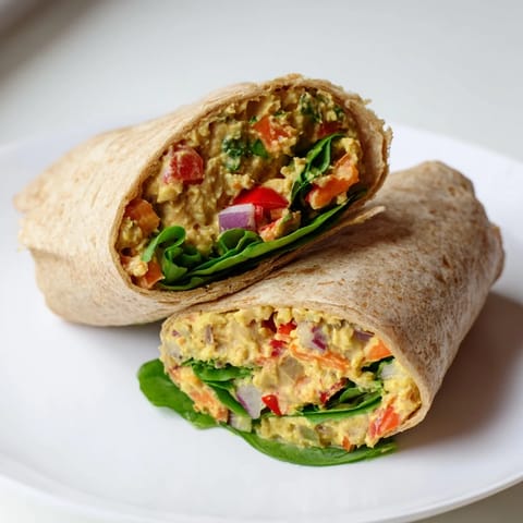 Creamy and flavorful chickpea salad filling a whole wheat wrap, perfect for a quick and healthy lunch.