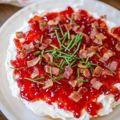 A vibrant, close-up shot of the Easy Bacon Pepper Jelly Appetizer with creamy cheese and spicy jelly.