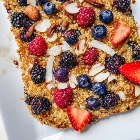 A close-up of a warm, comforting Berry Quinoa Breakfast Bake, bursting with fresh berry flavors.