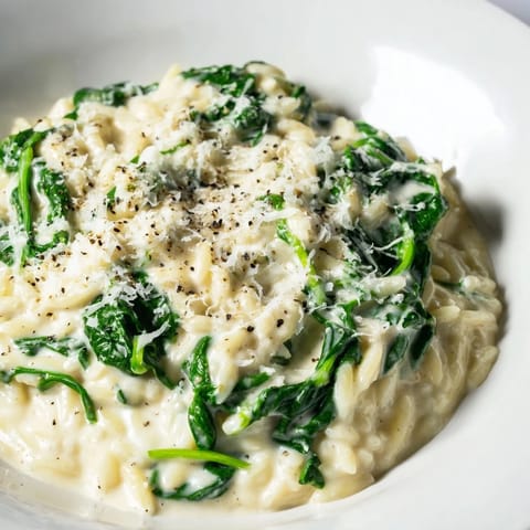 This creamy spinach orzo features tender pasta with wilted spinach, offering savory comfort.
