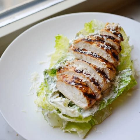 Creamy Caesar dressing drips down the side of this hearty Caesar Chicken Sandwich, served with golden fries.