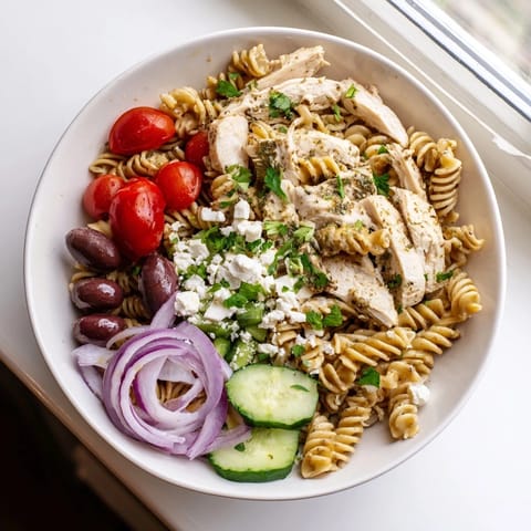 Tossed with crisp cucumbers and tangy dressing, this vibrant Greek Chicken Pasta Bowl makes a refreshing weeknight dinner.