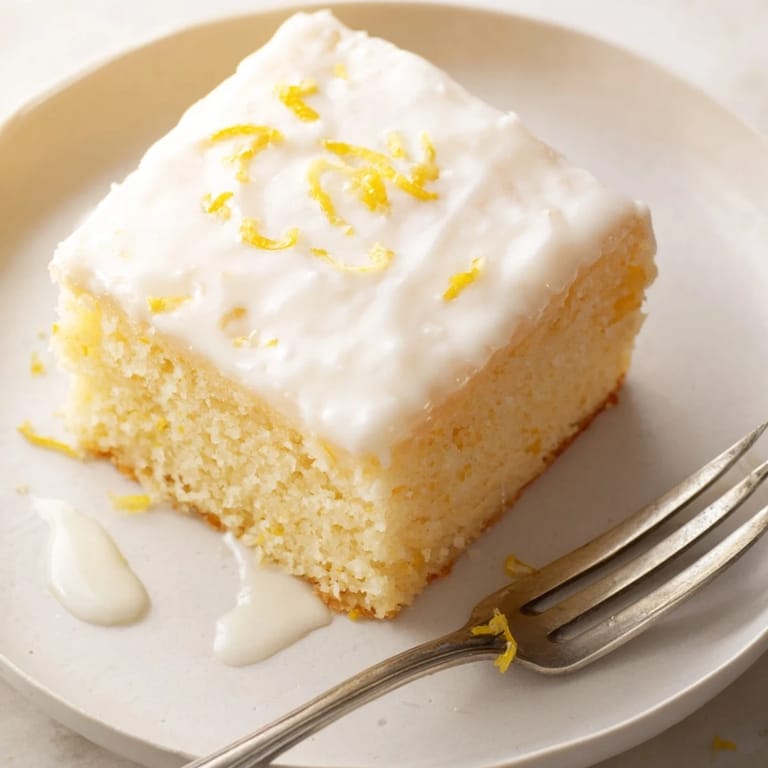 Delicious Lemon Soda Sheet Cake Squares served with fresh lemon slices and tea.  