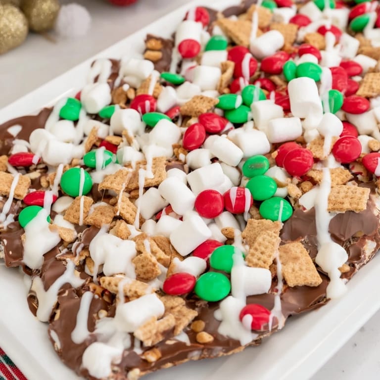 Melting chocolate forms the base of this Quick Christmas Smores Bark photo, layered with holiday candies and graham crackers.